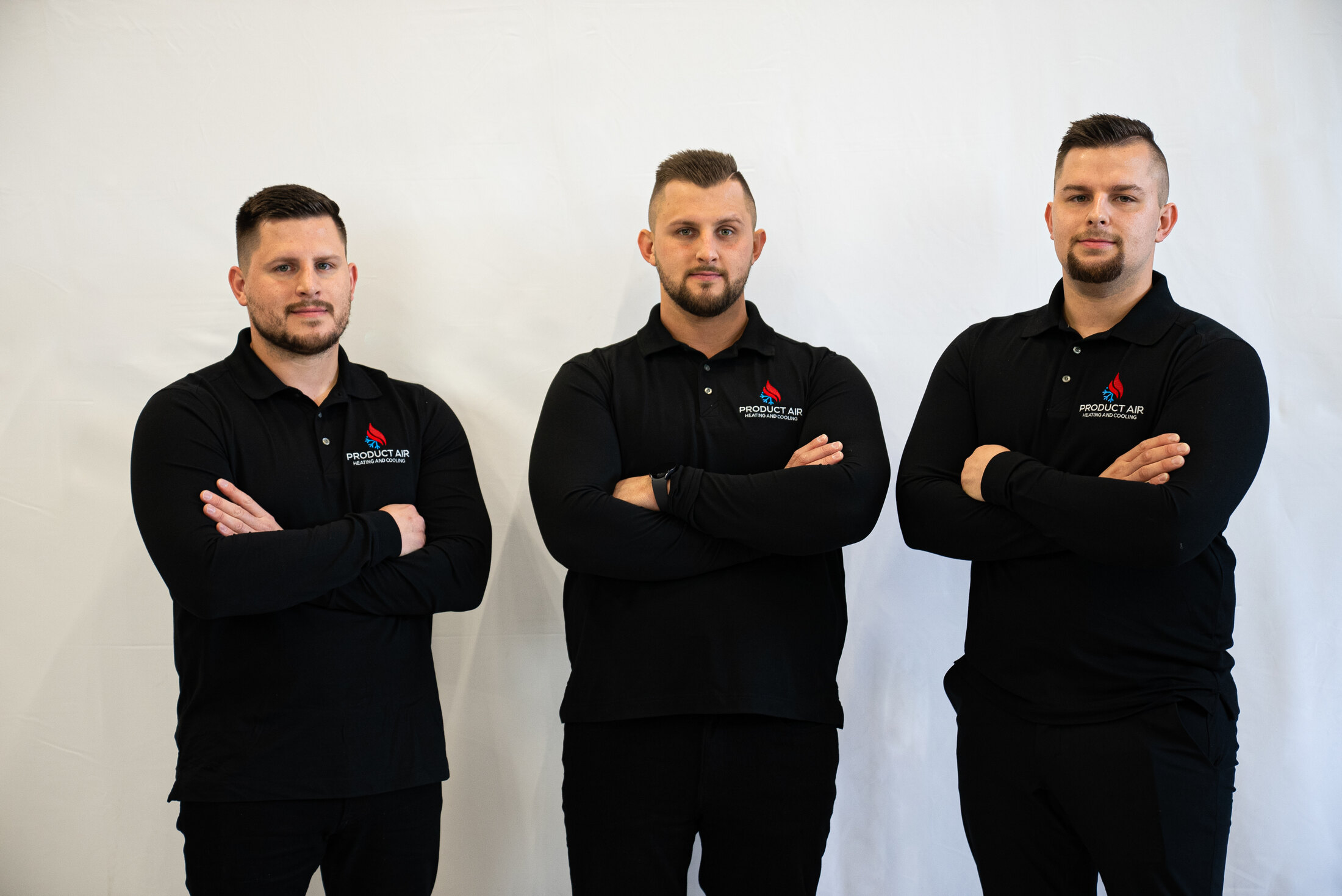 The three Product Air brothers in matching branded polos, arms crossed, on a white studio background